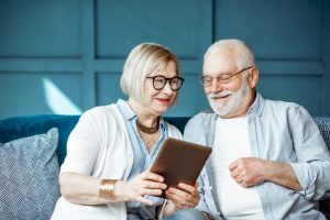 Mann und Frau Senioren Tablet fröhlich